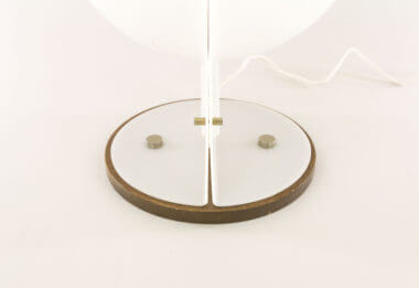 The base of a white table lamp made of 2 white half-spheres in molded plastic, resembling a Sirio lamp by Guzzini