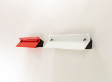 A pair of Stillnovo wall lamps, one red and one white, close together