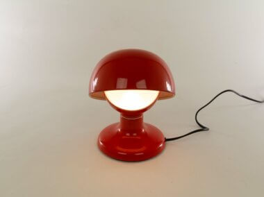 Red Jucker table lamp by Tobia Scarpa for Flos, switched on