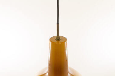 The brass detail of an amber Venini pendant by Massimo Vignelli