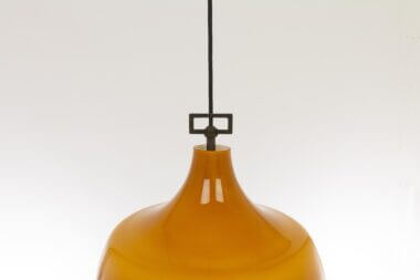 The tot of the fixture of an amber glass pendant by Massimo Vignelli for Venini