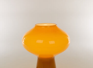 The top part of a Hand-blown amber Fungo table lamp (medium) by Massimo Vignelli for Venini, switched on